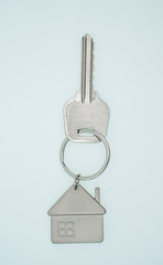 key chain with house symbol and keys on white background,Real estate concept