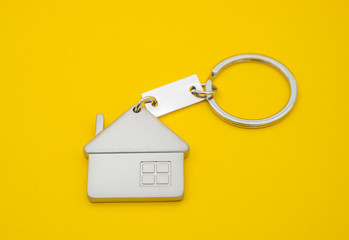 key chain with house symbol and keys on yellow background,Real estate concept