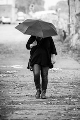 Portrait of woman  walking in the street with a black umbrella