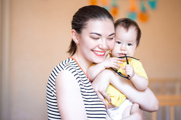 happy mother having fun with baby girl dark-haired mixed race kazakh and german caucasian russian