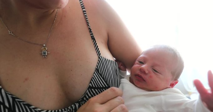 Mother holding newborn baby infant first days of life