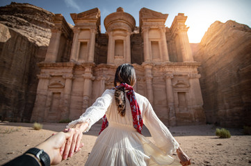 Asian woman tourist in white dress holding her couple hand at Ad Deir or El Deir, the monument...