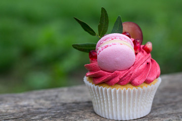 appetizing cupcakes decorated with macarons grape and pomegranate