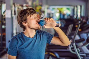 Fototapeta na wymiar Sport man drinking water in the gym