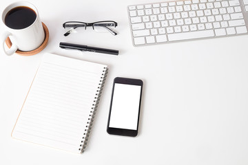 Top view white office desk table with blank notebook, computer keyboard and other office supplies. with copy space, flat lay.