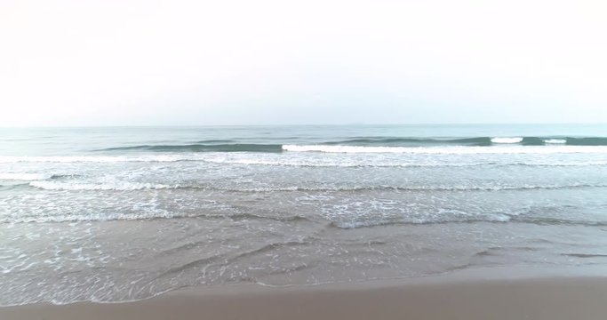 Drone flying above the waves coming into the Mae Pim beach Rayong Thailand