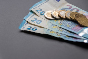 Stapel 20-Euro-Geldscheine mit Euro-Münzen (1 EUR, 2 EUR, 50 Cent)