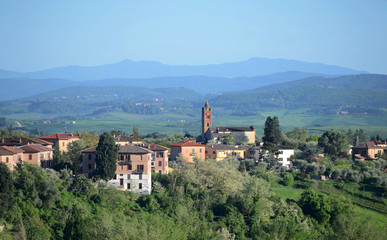 Fototapeta na wymiar scenic view of a section of Siena town with its old buildings and surrounding hills on a sunny spring da
