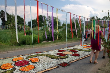 Kwietny dywan przygotowany ze świeżych kwiatów i roślin na procesję Bożego Ciała, tradycyjnie, w Spycimierzu, Polska, trasa udekorowana kolorowymi wstążkami