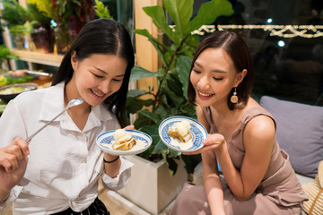 Two Beautiful Adult working women eat chocolate Pancake with icecream, smile happy enjoy eating atmosphere in restaurant, selective focus