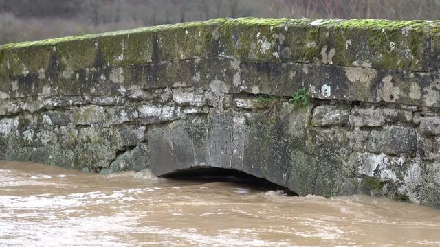 Hochwasser an einer Br&uuml;cke &uuml;ber einen kleinen Bach im Fr&uuml;hling