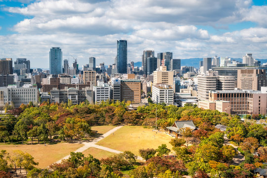 Osaka Cityscape in Kansai region, Japan - View from Osaka Castle with the park surrounding the castle in autumn in the foreground.
