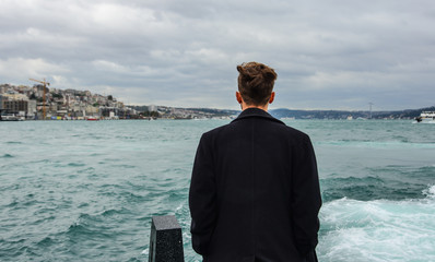 Fototapeta premium A young man standing at the jetty