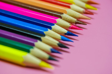 Color Pencils on a pink paper background. Selective focus