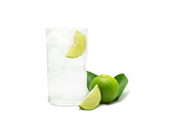 Glass of sparkling water soda with ice and lime slice on white background.