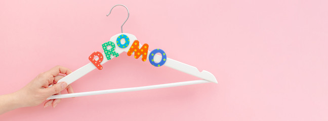 White hangers with promo text on pink background