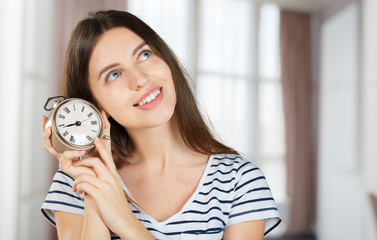 Happy business woman holding a clock isolated
