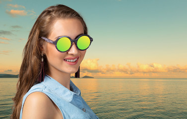 Portrait of fashion woman peeking over sunglasses. Female fashion model posing