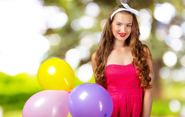Naklejka premium Smiling woman holding balloon and looking at camera