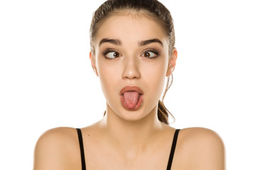 Young beautiful woman making funny faces on white background