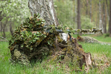 Camouflaged sniper in the forest