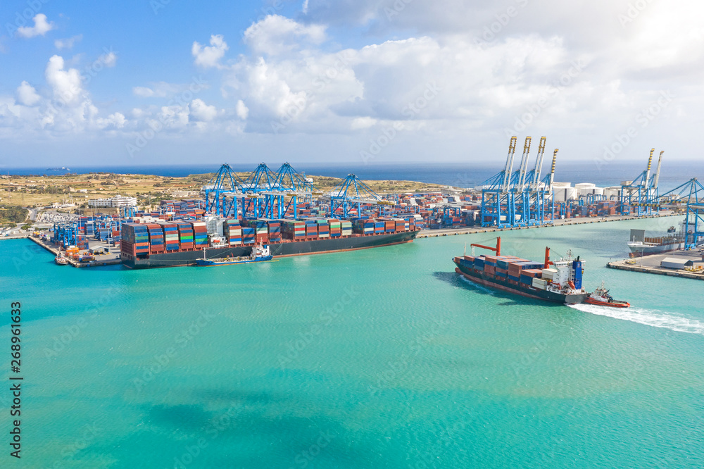 Wall mural aerial view from the height of a cargo harbor in a cargo seaport, a sailing ship with containers, an