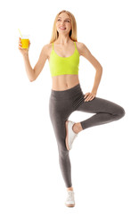 Sporty young woman with glass of juice on white background