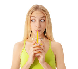 Sporty young woman with glass of juice on white background