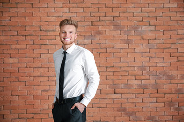 Portrait of businessman near brick wall