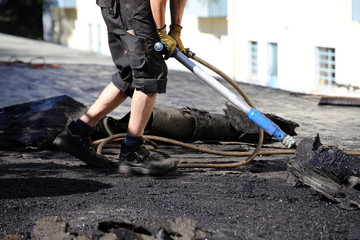 Dachdecker entfernen alte Bitumen und Dachabdichtung