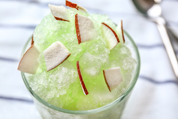 Glass with tasty shaved ice on table, closeup