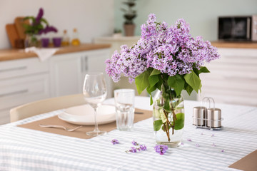 Beautiful lilac flowers on table in kitchen