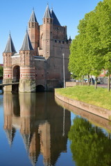 Fototapeta na wymiar Reflections of the Amsterdamse Poort city gate (built between 1400 and 1500) in Haarlem, Netherlands