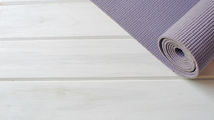 closeup Purple yoga mat on white wood floor
