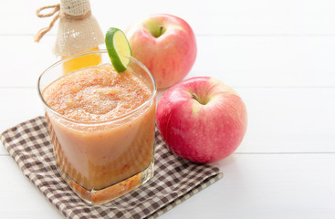 Healthy drink,Reduce cholesterol in the blood vessels of smoothies with red apple and lemon, Honey bottle in a glass on white wooden background