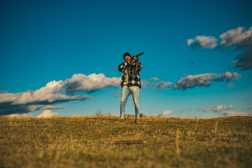 Hunter with a backpack and a hunting gun in the autumn forest. Hunter with shotgun gun on hunt.