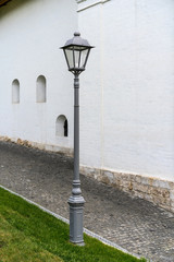 old street lamp on a paved sidewalk near an old building