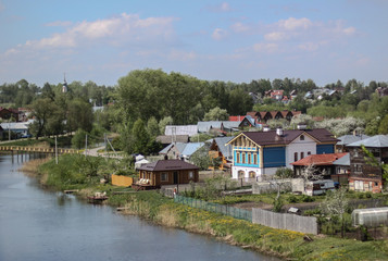 Fototapeta na wymiar View of Suzdal town and Kamenka river in sunny day of May