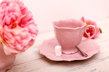 Big roses and coffee on a white wooden background.