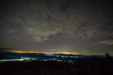 Starry sky over the city in the fog