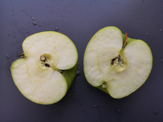 Green apples slice on gray background.