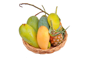 Isolated of Thai local fruit as green mangos, ripe mango,sweet mango and pineapple in the wood basket.