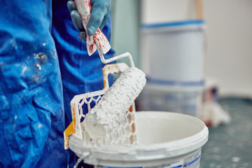 Worker painting walls inside the house - renovation fixes.