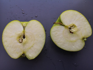 Green apples slice on gray background.