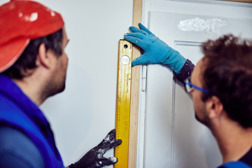 Two handymen working together on a house renovation.