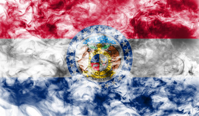 The national flag of the US state Missouri in against a gray smoke on the day of independence in different colors of blue red and yellow. Political and religious disputes, customs and delivery.