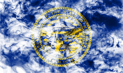 The national flag of the US state Nebraska in against a gray smoke on the day of independence in different colors of blue red and yellow. Political and religious disputes, customs and delivery.