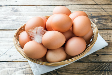 Fresh chicken eggs in the basket. Rustic wooden style background.