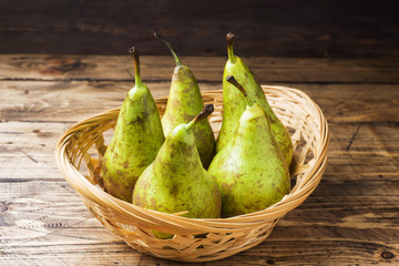 Fresh juicy Pears Conference in a basket on a wooden rustic background.