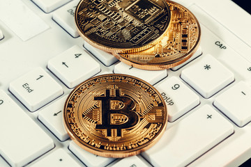Golden bitcoin coin cryptocurrency on the laptop keyboard.